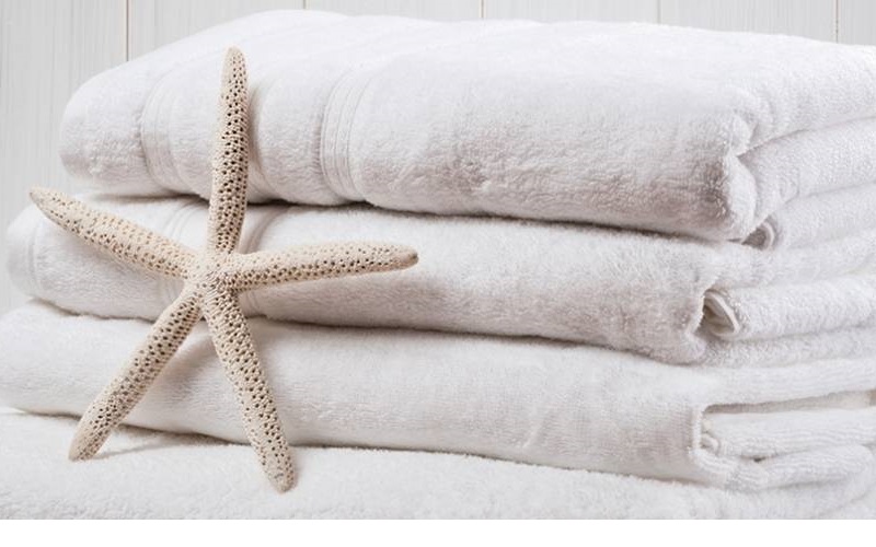 Clean set of towels with a coral starfish in front